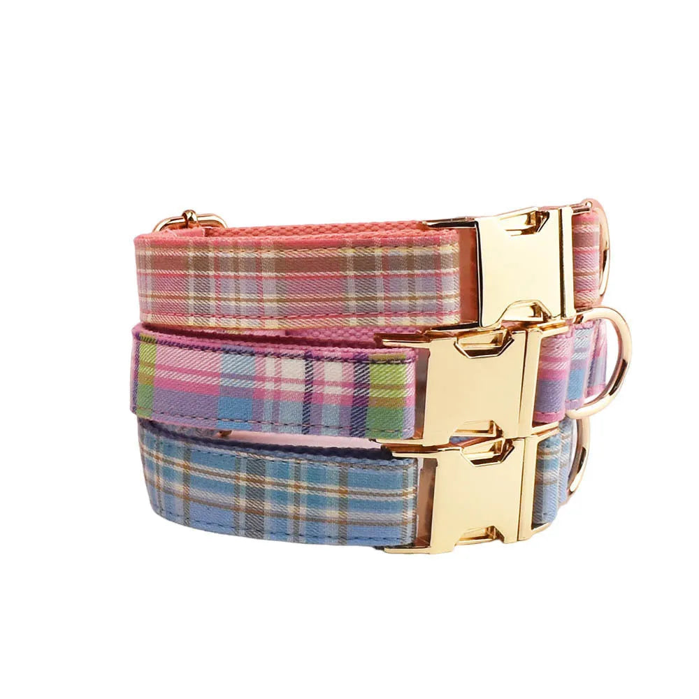 Sky blue grid pattern dog collar, leash, vest, and bow set laid out on a white background.