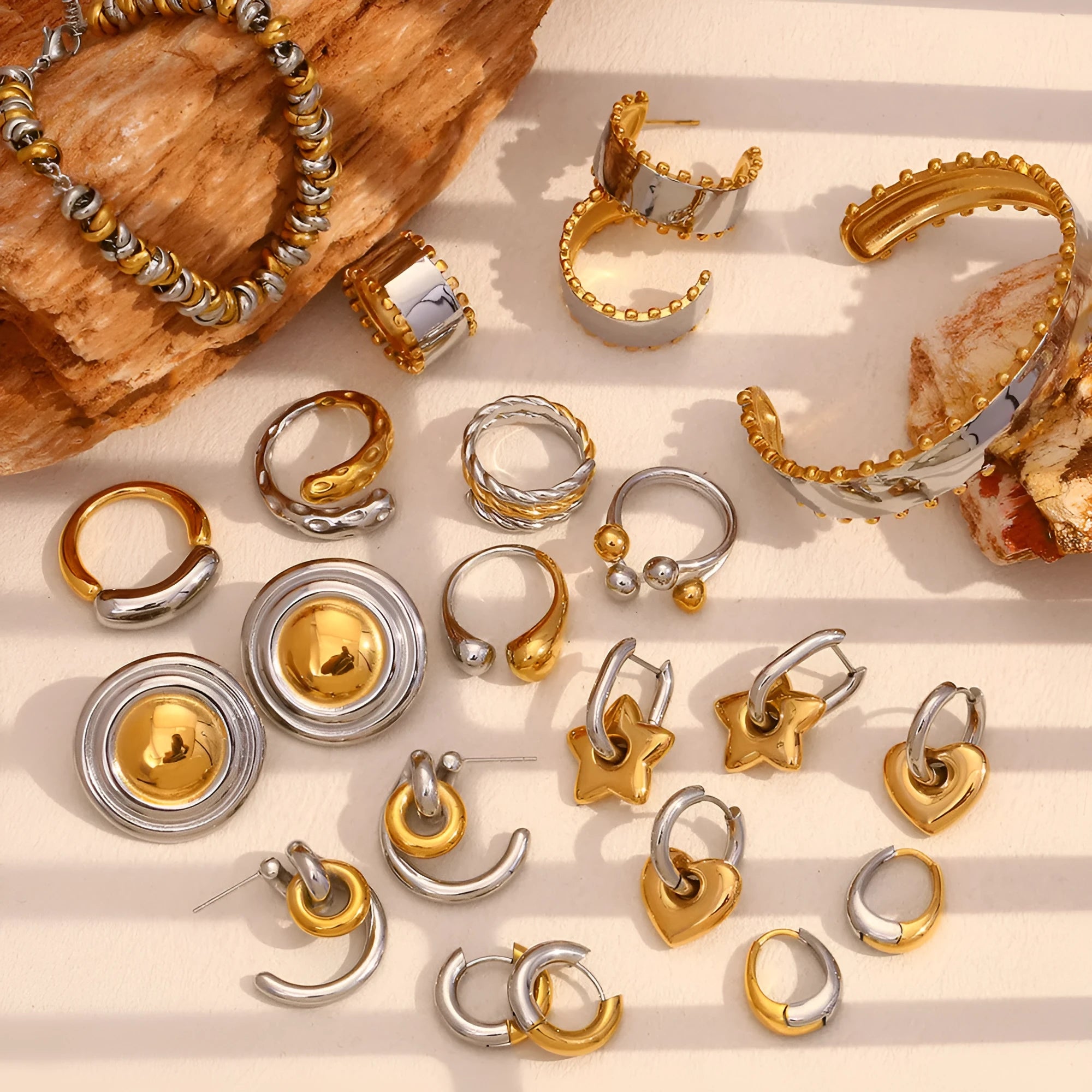 Gold-colour women's jewellery set with geometric earrings, round ring necklace, and matching bracelet on a grey background.
