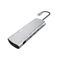 Grey aluminium USB-C docking station with HDMI, VGA, USB 3.0, and PD charging ports on a desk.
