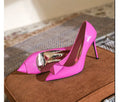 Women's pink patent leather pointed toe stiletto heels with buckle and rivet detail on a shallow cut.