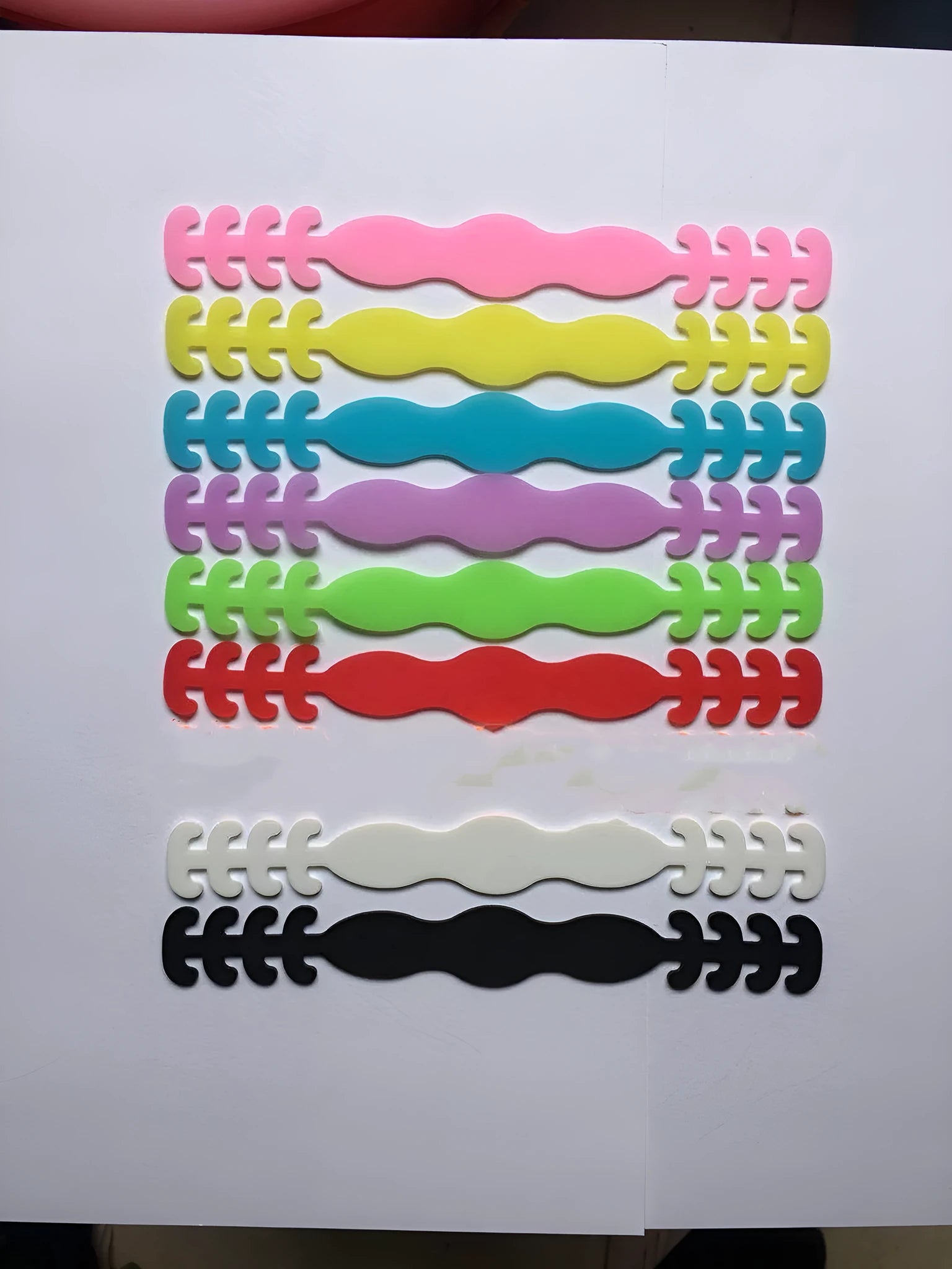 Pack of eight coloured silicone tool buckle straps on a workbench