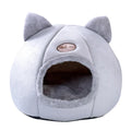 Grey enclosed cat sofa bed with a round entrance hole, showing a soft plush interior and removable cushion.