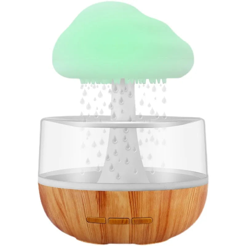 White cloud-shaped ultrasonic humidifier with coloured LED night light on a table.