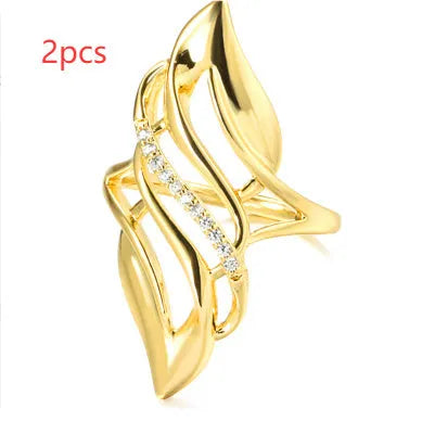 Gold women's ring with exaggerated curved design on a copper band, shown in casual style.