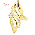 Gold women's ring with exaggerated curved design on a copper band, shown in casual style.
