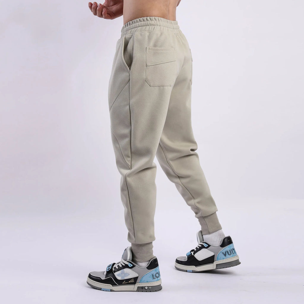 Man wearing grey ankle-tie drawstring sweatpants for casual leisure.