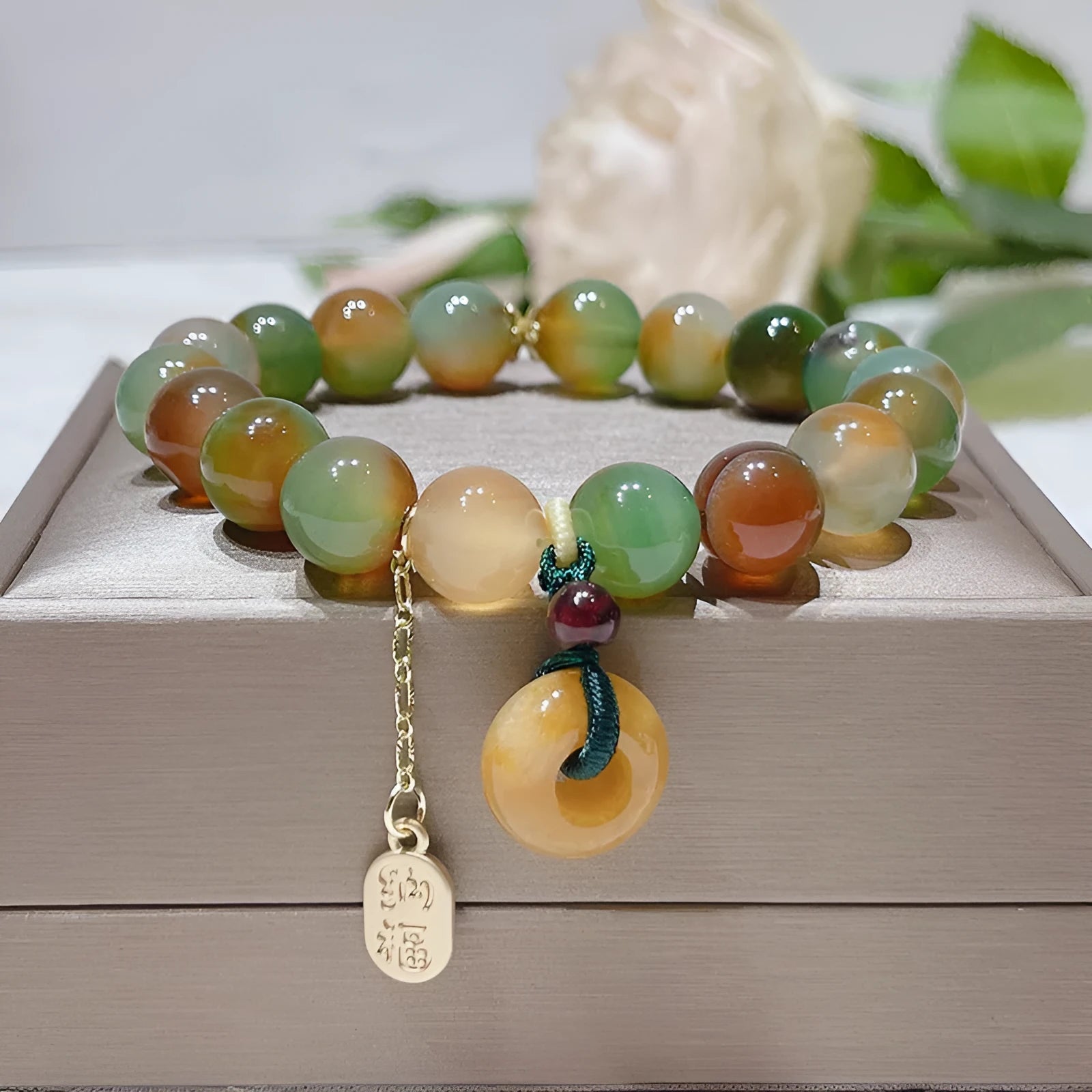 Yellow peacock agate and topaz beaded bracelet with a metal safety chain and peace buckle clasp.