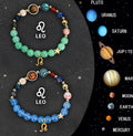 Set of twelve natural stone beaded bracelets with gold zodiac charms on a white background.