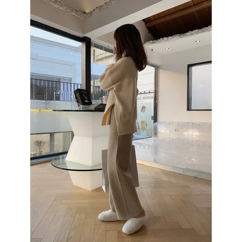 Woman wearing cream white knitted high-waist wide-leg winter trousers.