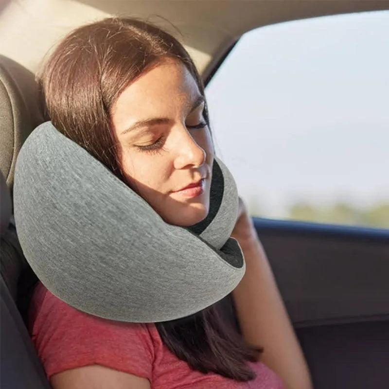 Navy blue U-shaped travel neck pillow rolled up next to its carry bag