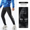 Men's grey blue sweatpants with ankle ties laid flat, showing mid-waist and tapered leg design.
