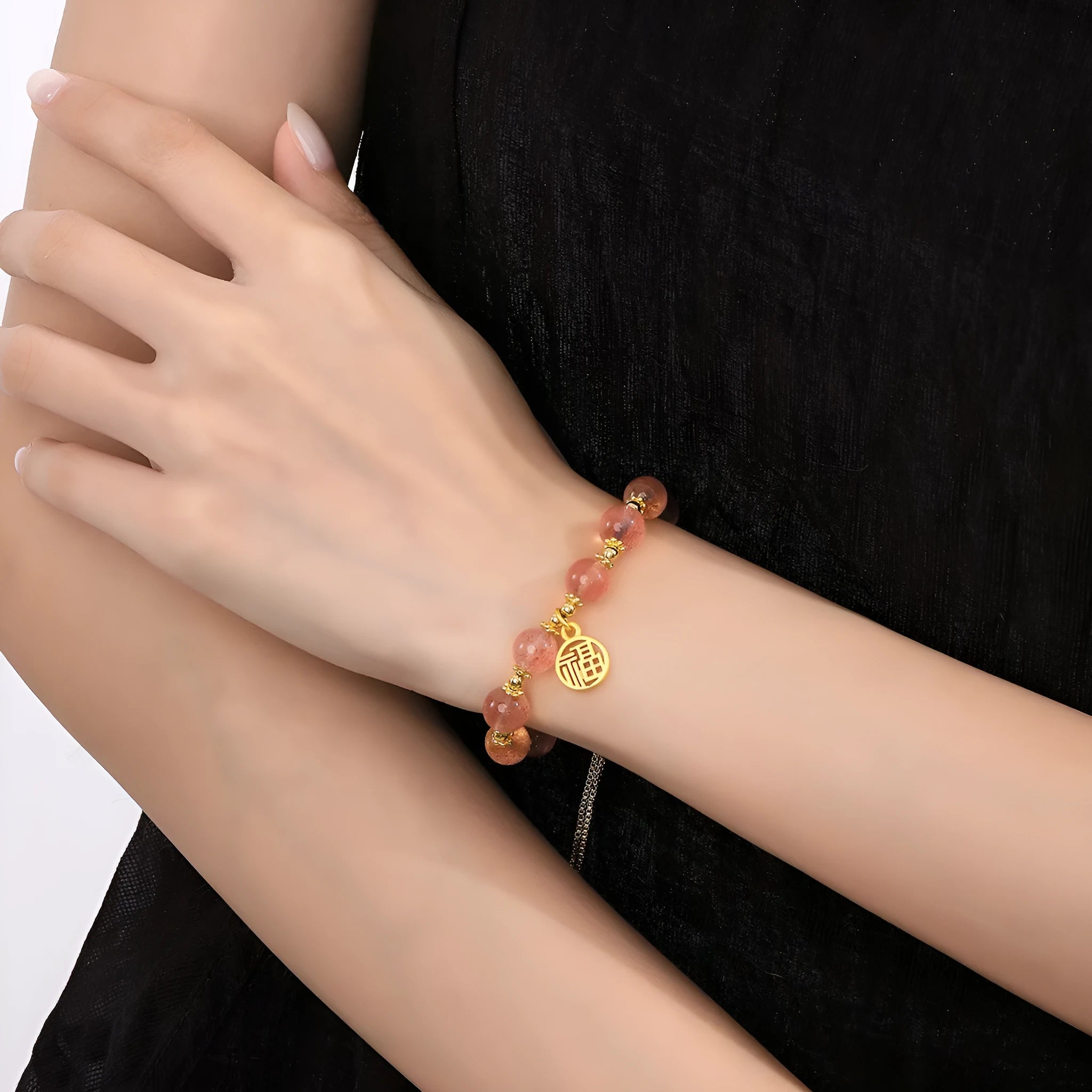 Women's Strawberry Quartz crystal bracelet with geometric design and fu character charm on wrist