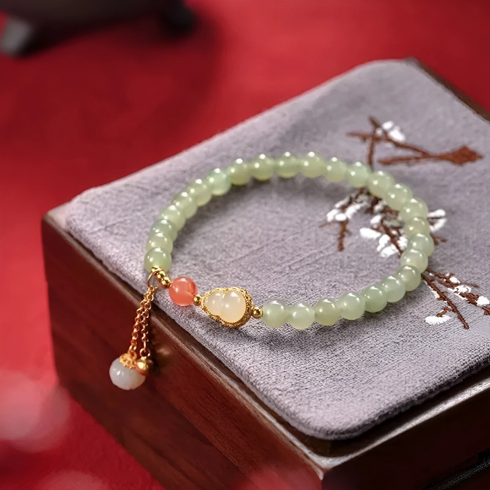 Natural jade bead bracelet with a gold-plated gourd charm and fu character.