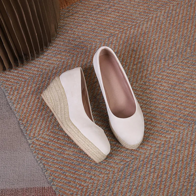 Women's apricot wedge heel pumps with round toe and thick sole on a white background.