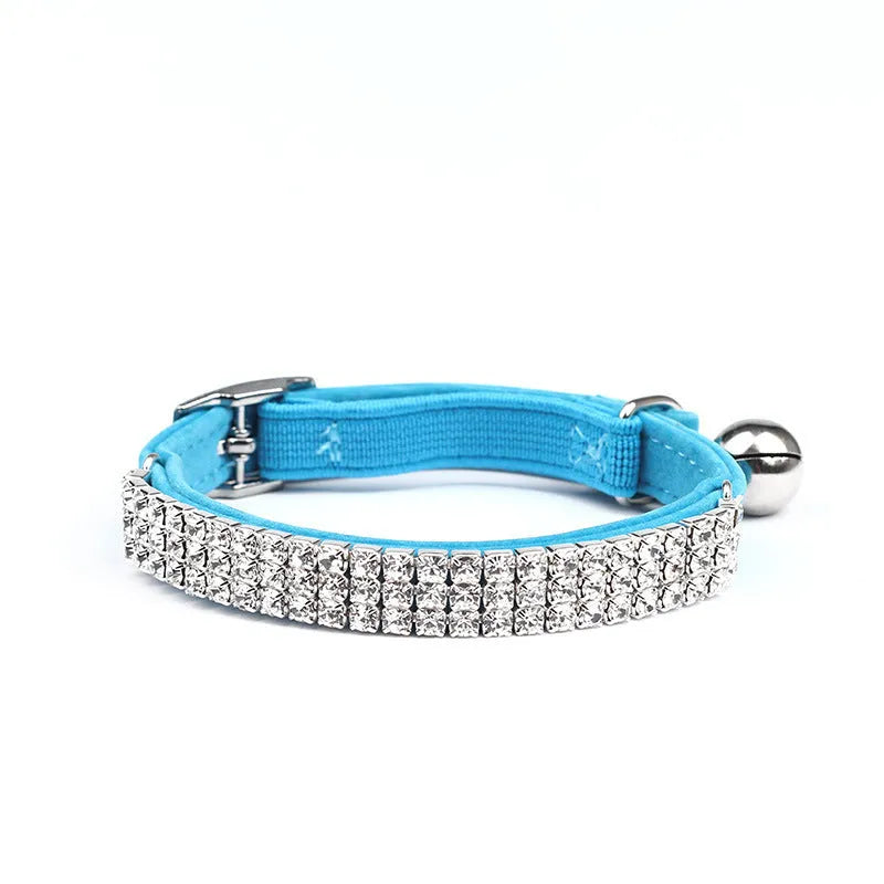 Red velvet cat collar with a line of sparkling rhinestones, showing the adjustable buckle.