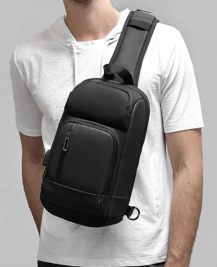 Black medium outdoor PVC shoulder bag with an air cushion strap and organiser pockets.