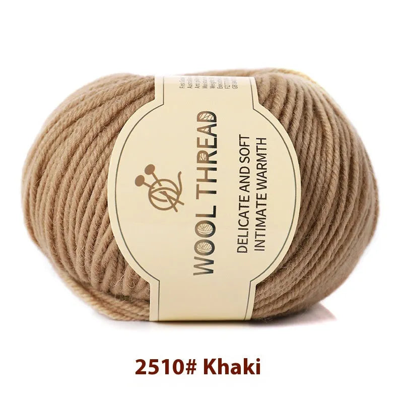 One roll of beige domestic wool hand-knitting yarn for size 10 needles next to knitting needles.