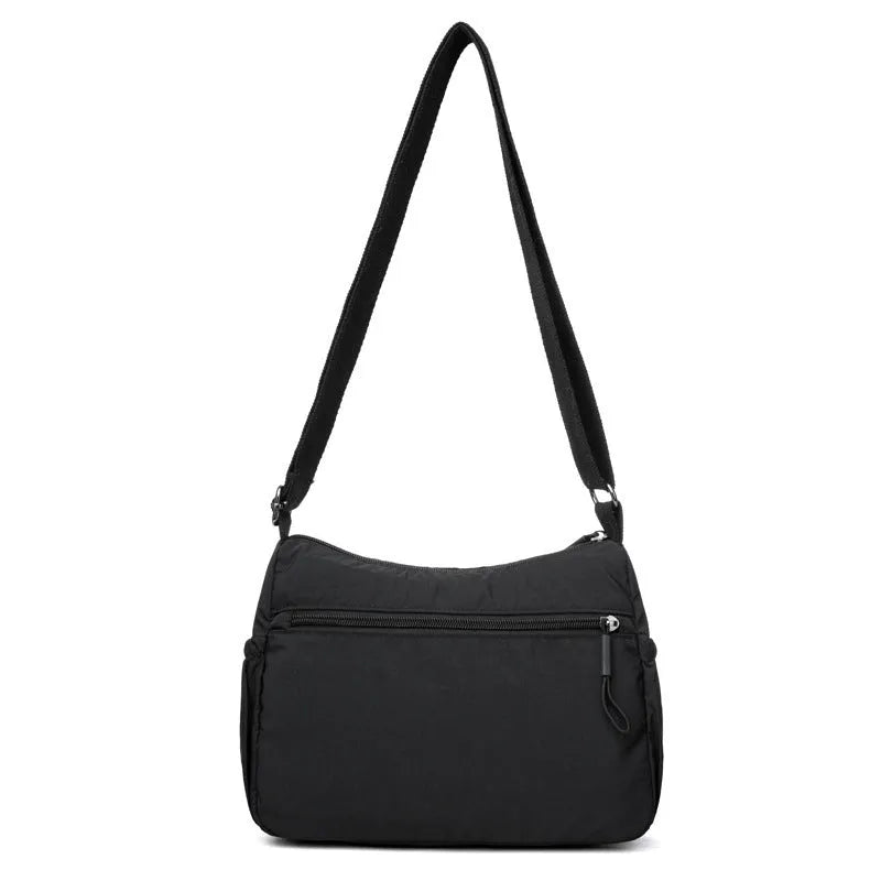 Soft water-repellent nylon crossbody bag showing three-dimensional pocket and adjustable shoulder strap