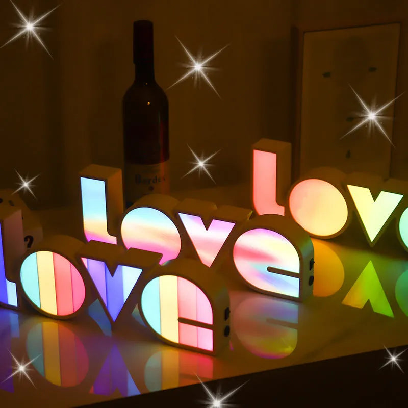 Rainbow colour LED LOVE light decoration for Valentine's Day or weddings on a desk.
