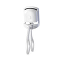 White USB rechargeable heated eyelash curler with a curved design and a small LED light.