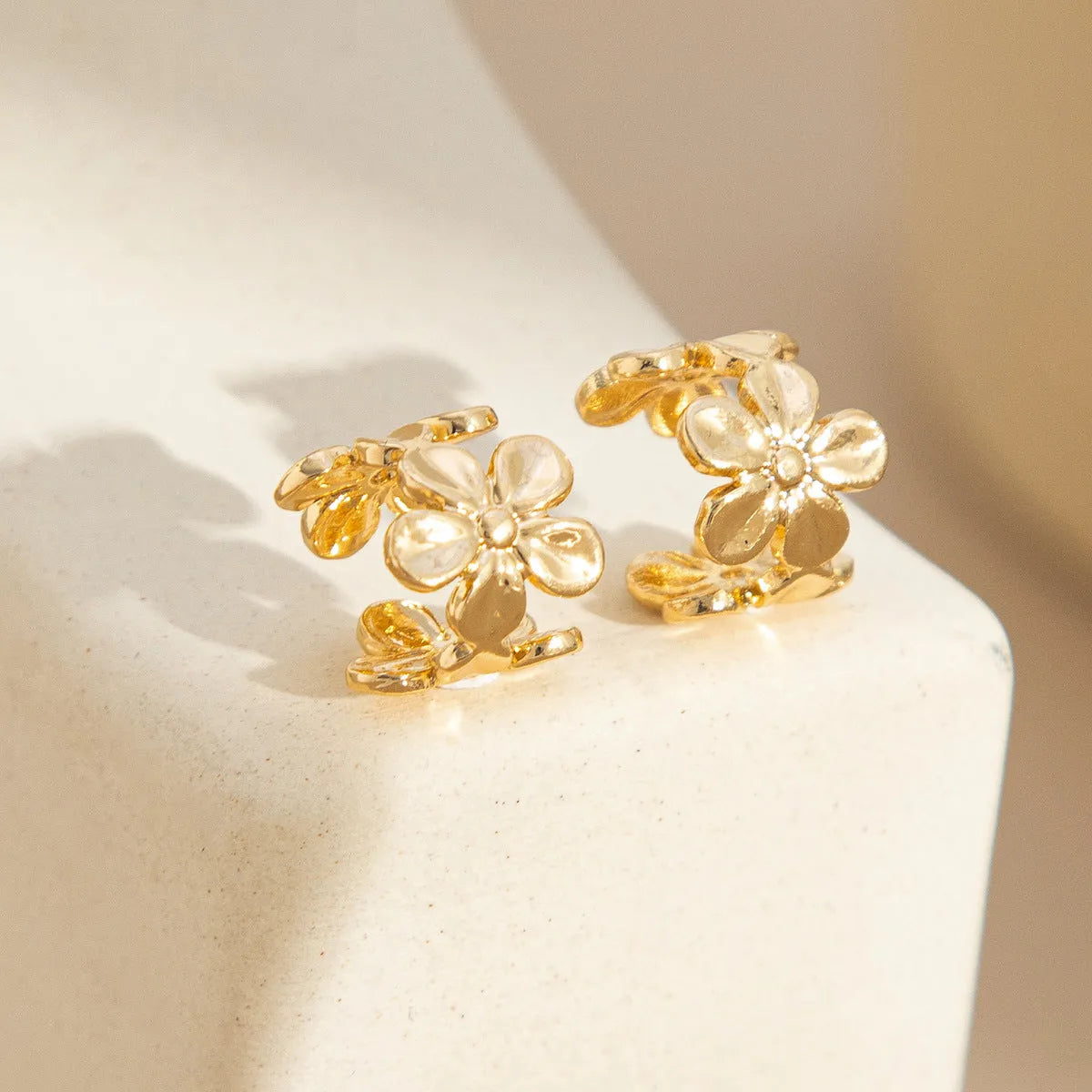 Gold-coloured starfish and scallop shell women's alloy earrings on a white background.