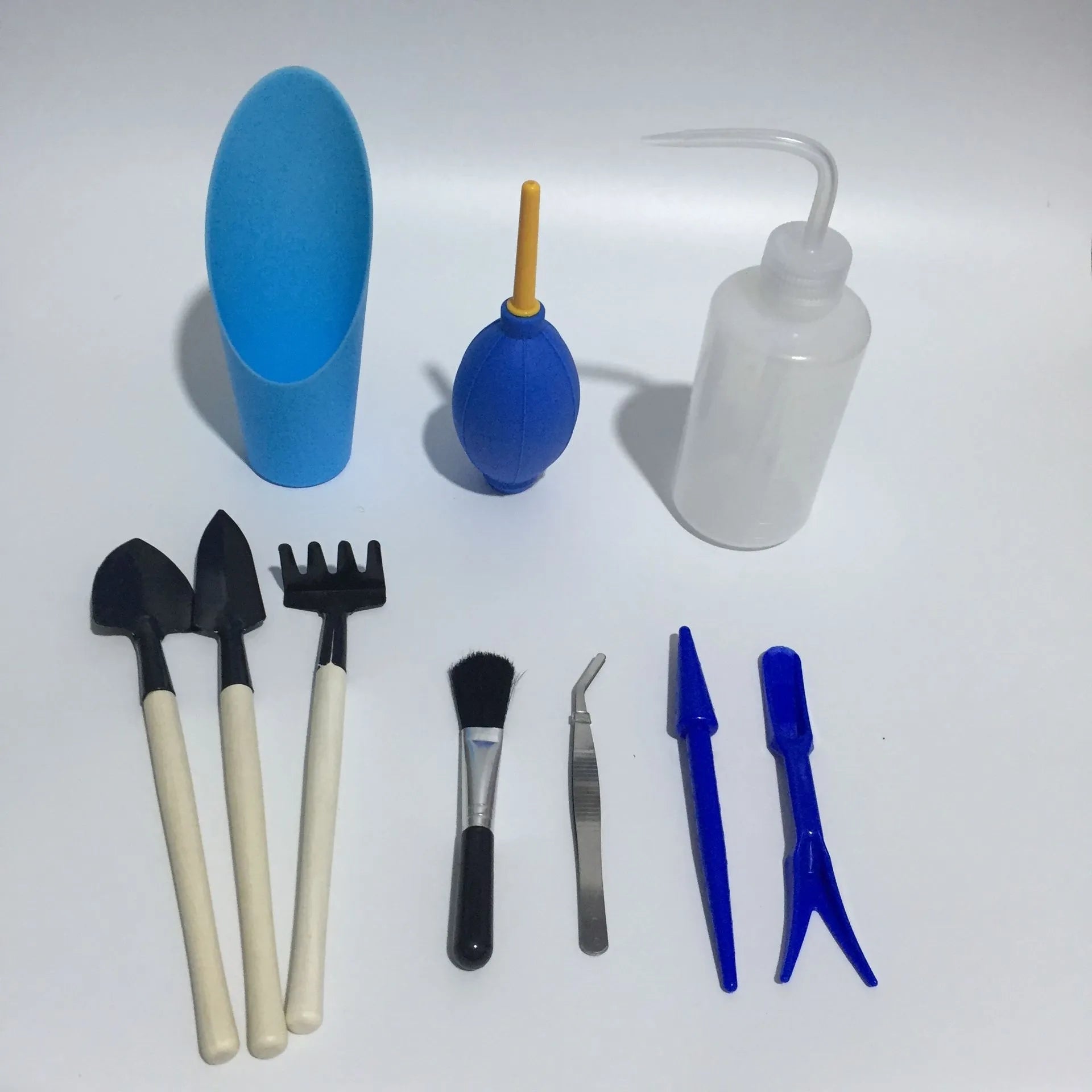 Succulent gardening tool set showing watering can, bucket, mini tools, tweezers, and scissors for small plant care.