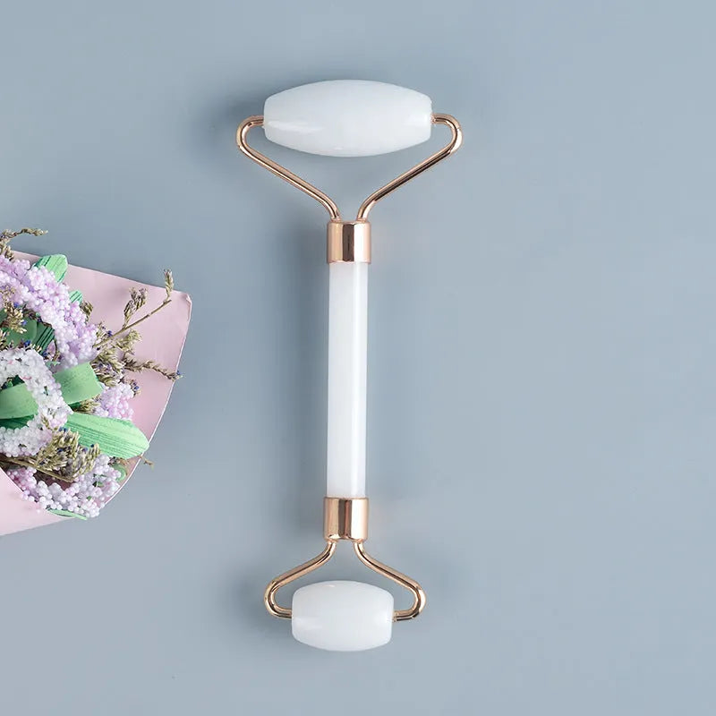 White jade double-headed facial roller and gua sha scraping tool set on a storage board.