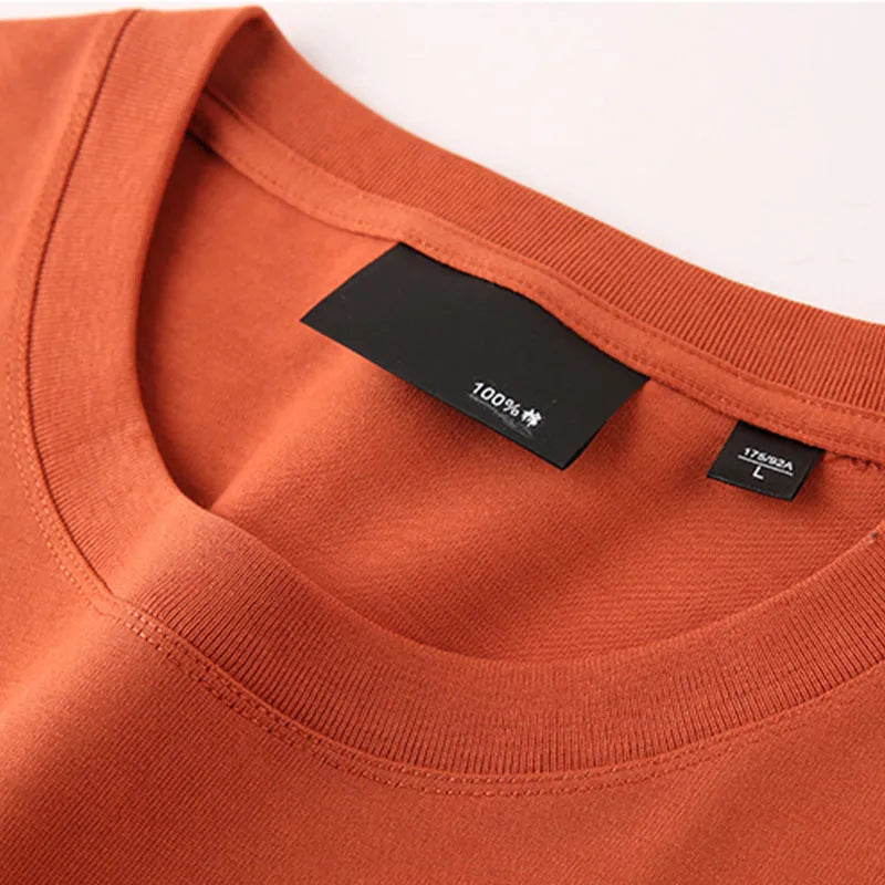 Man wearing a loose-fitting solid colour cotton t-shirt with drop-shoulder sleeves.