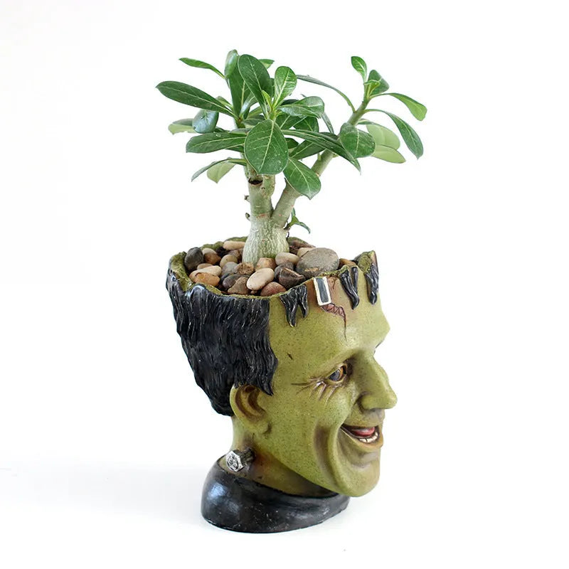 Green Man resin flower pot with sculptural relief detail on white desktop