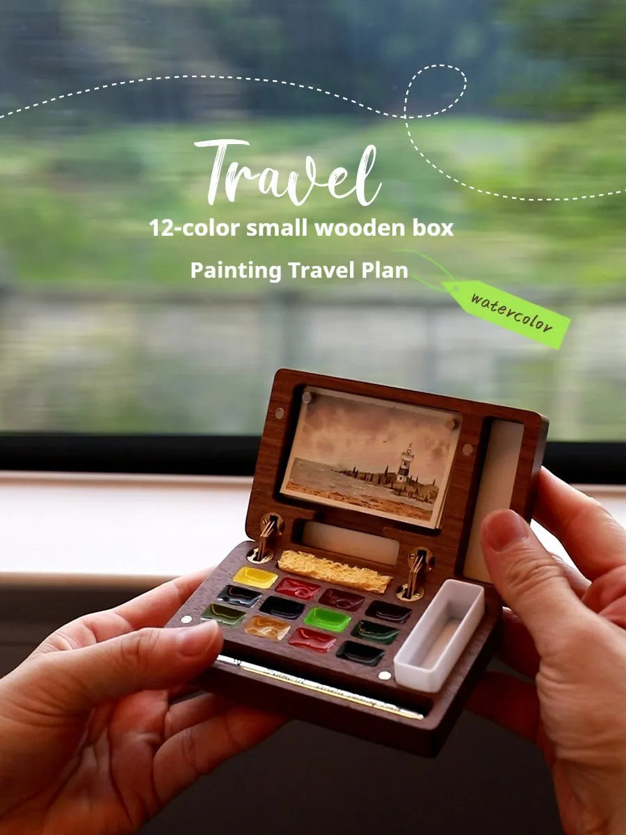 Mini walnut-finished wooden watercolour paint box open to show pigment suit pans inside.