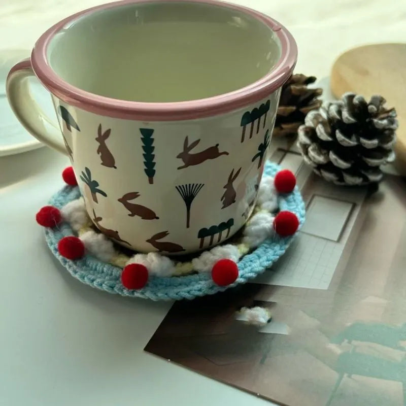 Circular wool felt coaster with cake design, 9 cm in diameter, shown on a table.