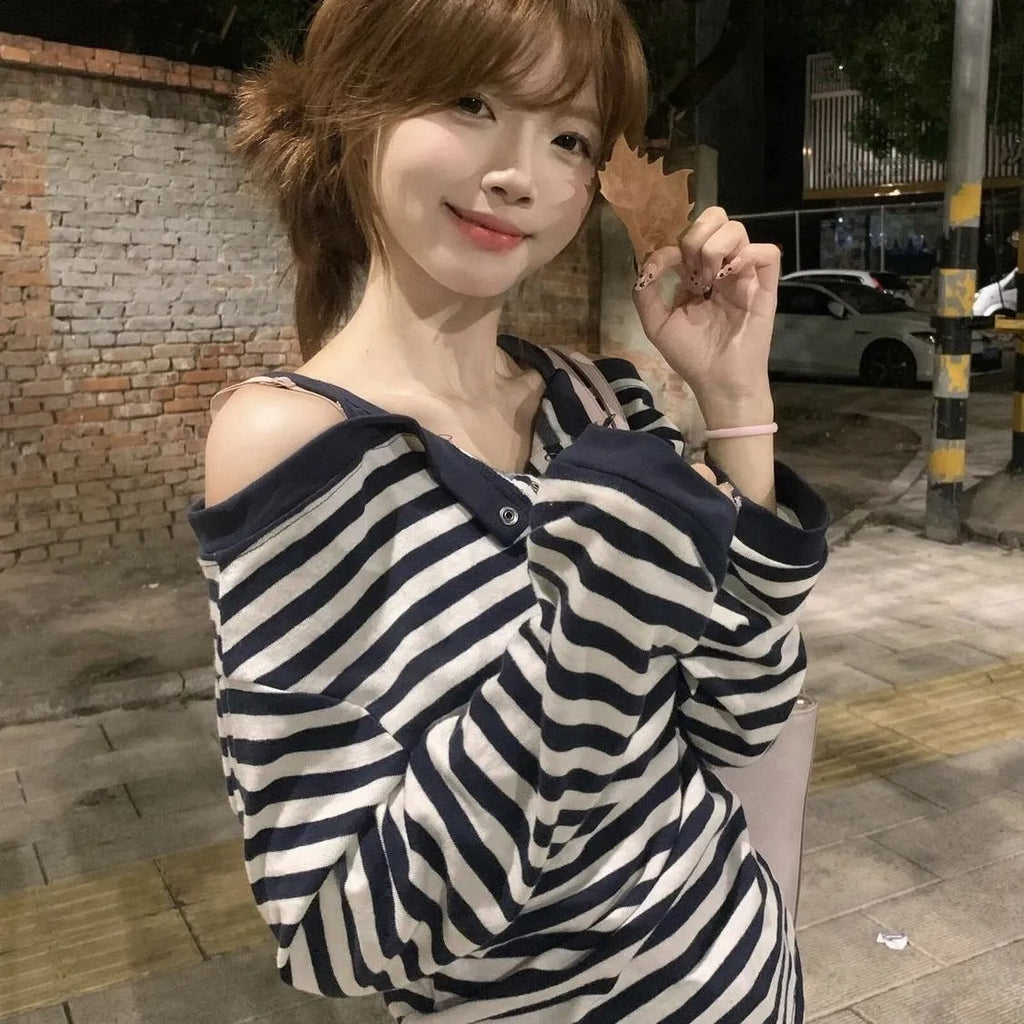 Dark blue women's oversized long-sleeve T-shirt with embroidered stripes and button details.