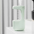 White columnar anti-gravity humidifier with LED clock display and mist output on a wooden desk.