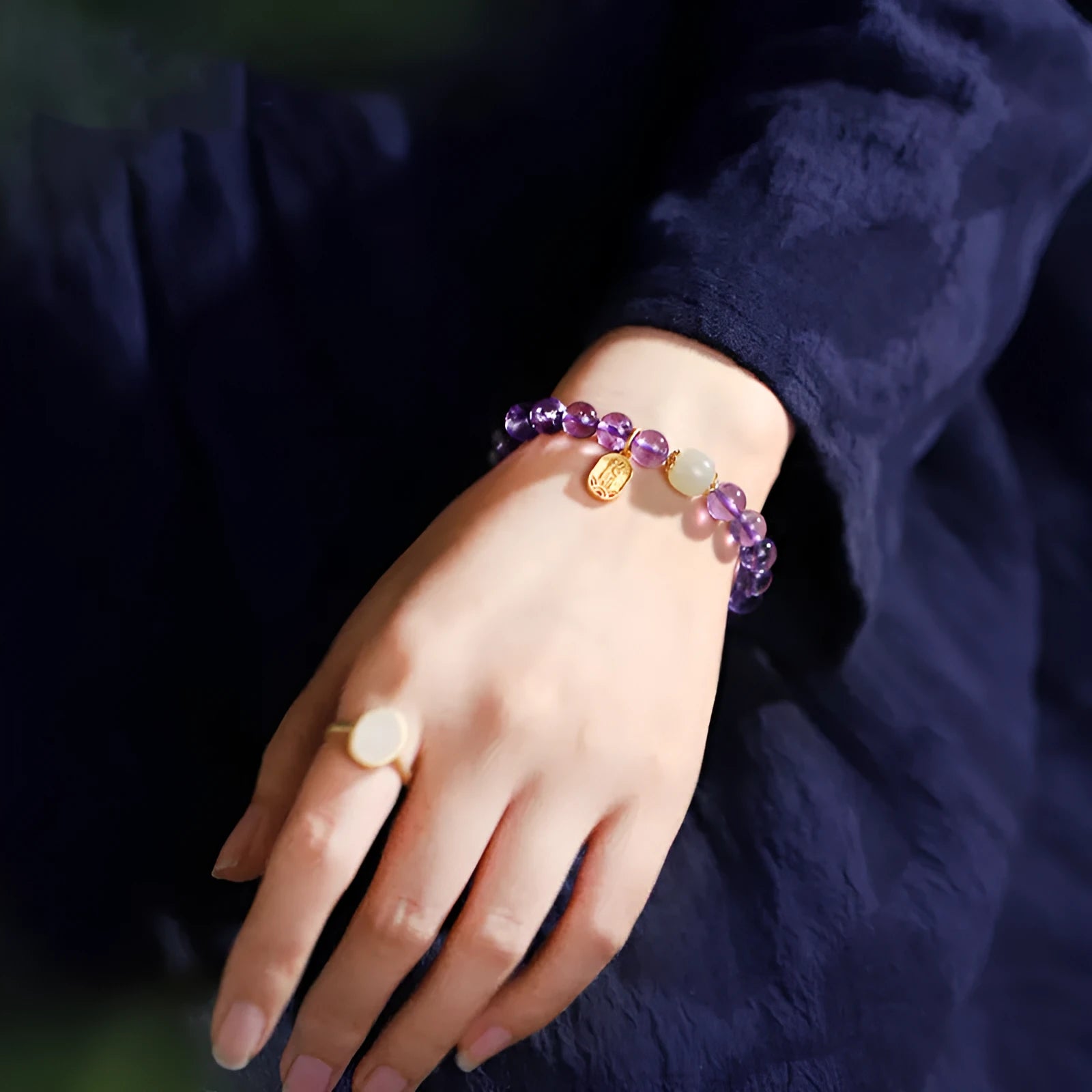 Close-up of a women's amethyst bracelet with 8mm geometric crystal beads on a wrist.