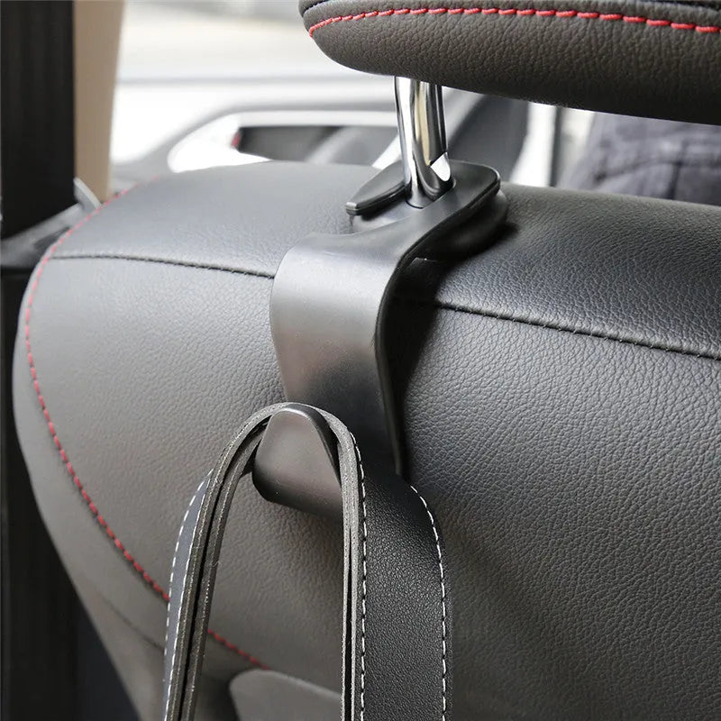 Set of four black PP plastic universal car seat back hooks on a car front seat backrest