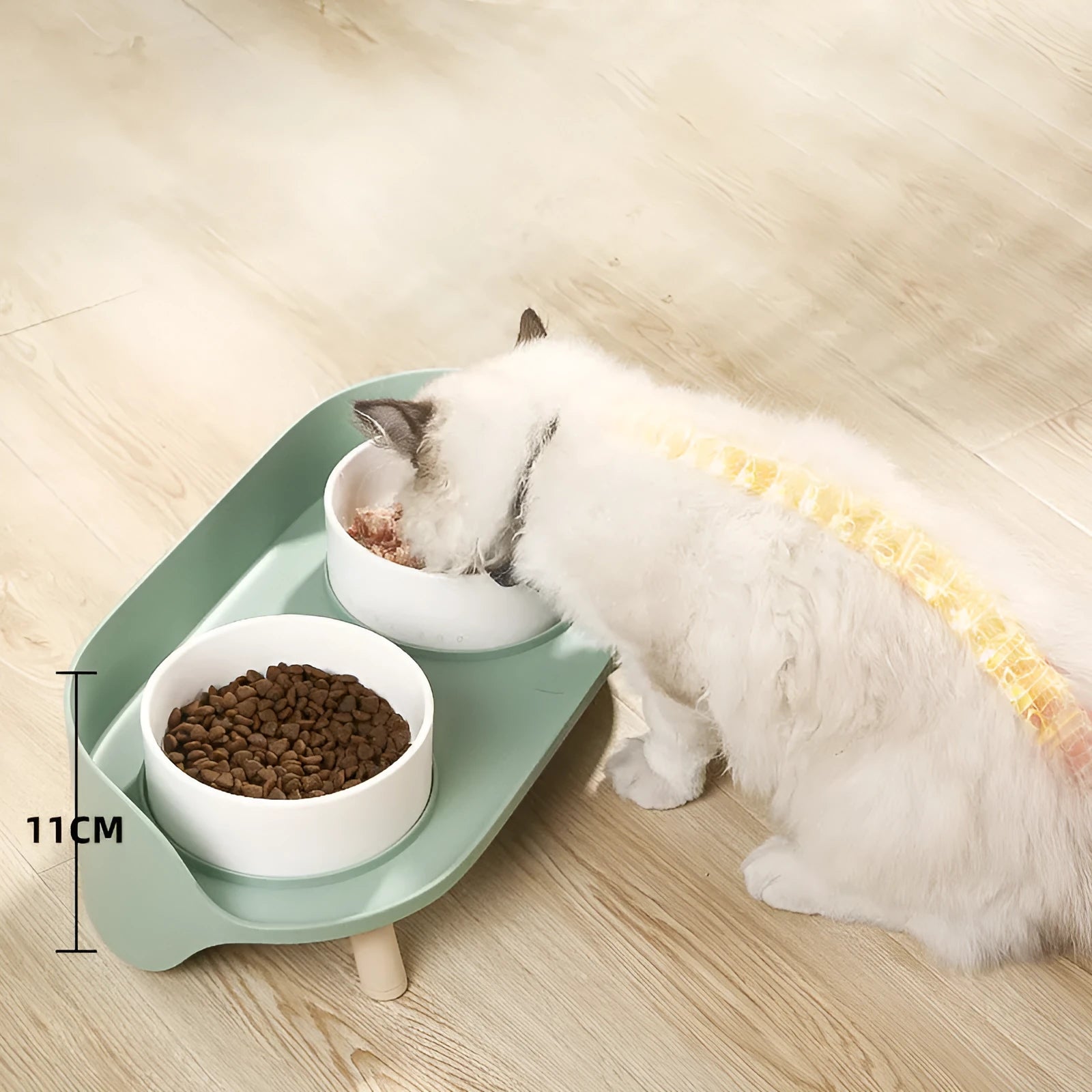 Green and white tilted pet feeder with two bowls for cats and dogs on a non-slip base.
