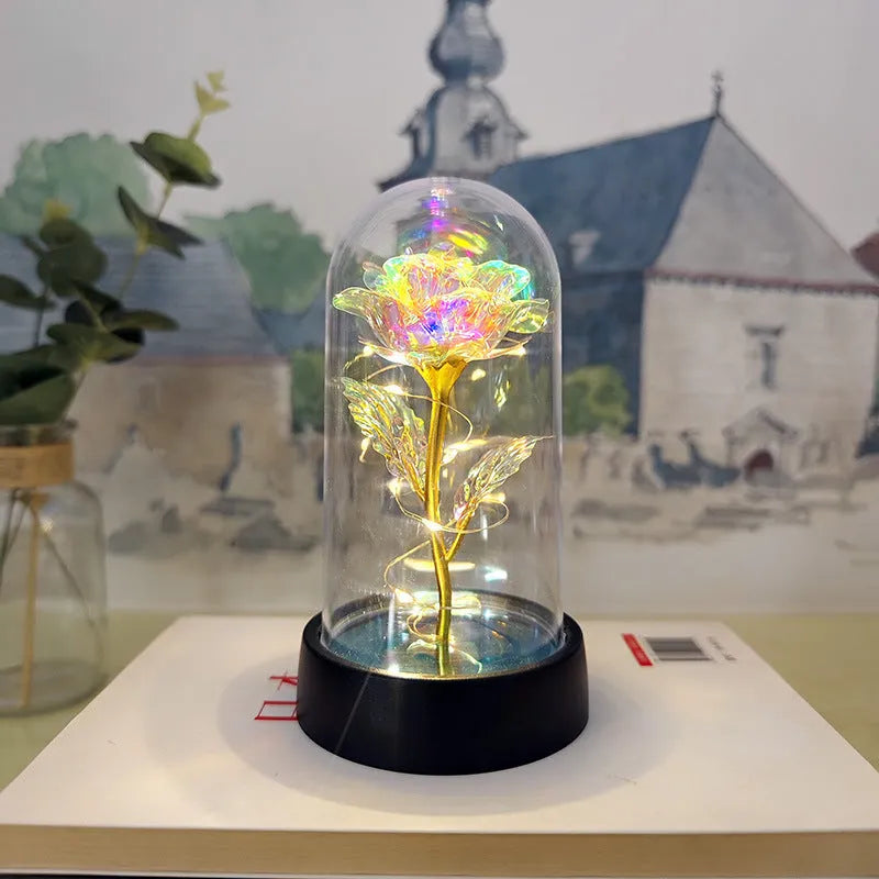 Small decorative night lamp with plastic flowers and a glass-style cover on a black base.