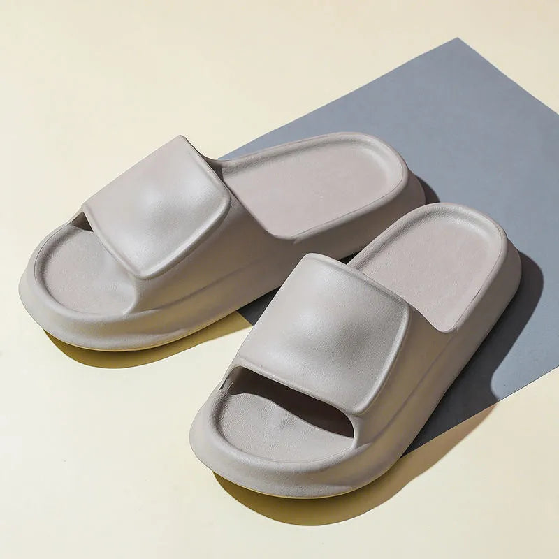 Pair of white EVA flip-flop slippers with a thick, textured sole on a tiled floor.
