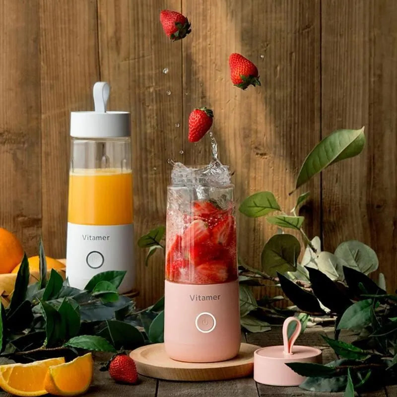 White portable USB rechargeable blender bottle with silicone lift ring, shown next to its charging cable.