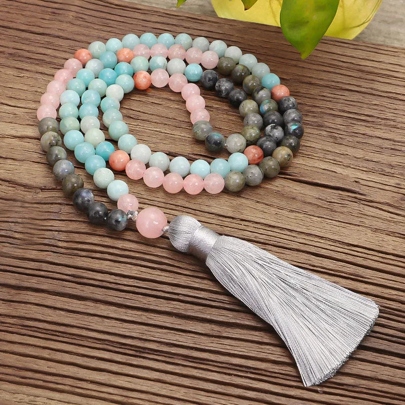Bohemian style necklace and bracelet set with colourful drop-shaped stone pendants and tassel details on a white background