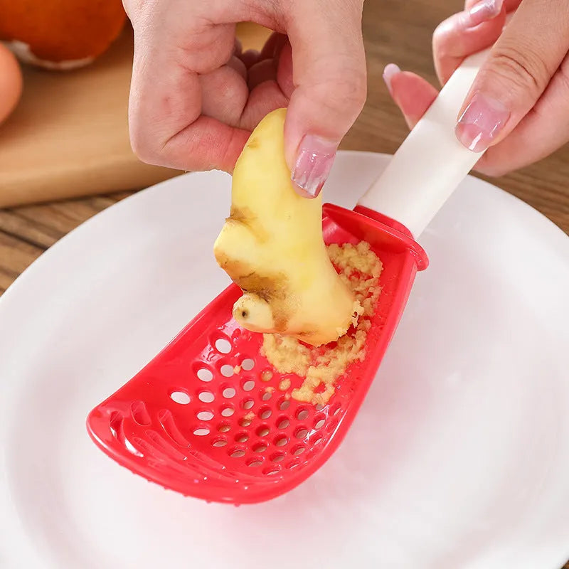 Red plastic multifunctional slotted spoon with half-enclosed head and convex serrations for cooking tasks