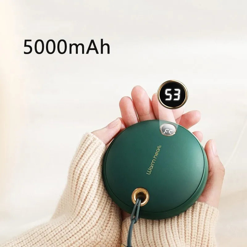 Green 5000mAh power bank hand warmer with digital display shown next to its charging cable.