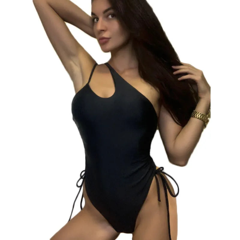 Black tight-fitting sleeveless women's dress with lacing detail and sloping shoulders.