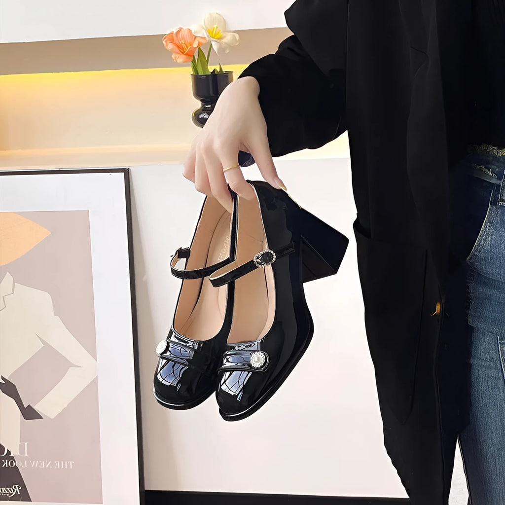 Women's black patent leather wide fit shoes with chunky heel and round toe, showing buckle fastening