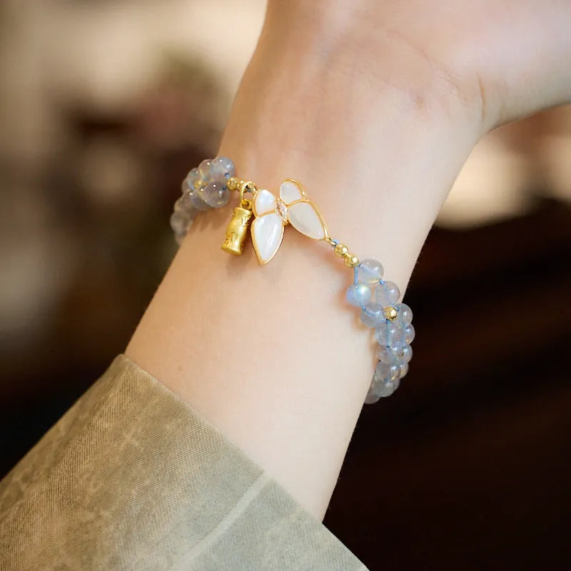 Grey moonstone butterfly charm on a handwoven cord bracelet for women.