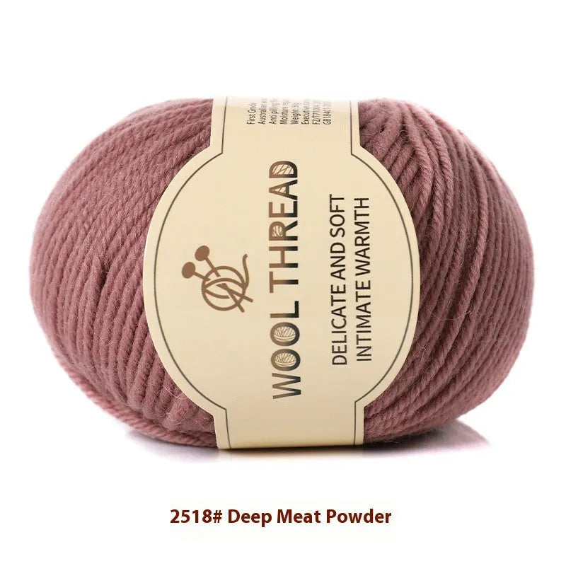 One roll of beige domestic wool hand-knitting yarn for size 10 needles next to knitting needles.
