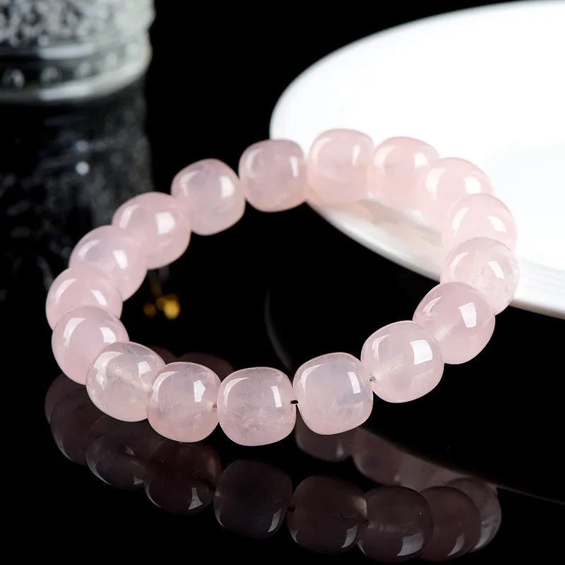 Pink natural bamboo crystal bracelet with geometric barrel beads on a wrist.