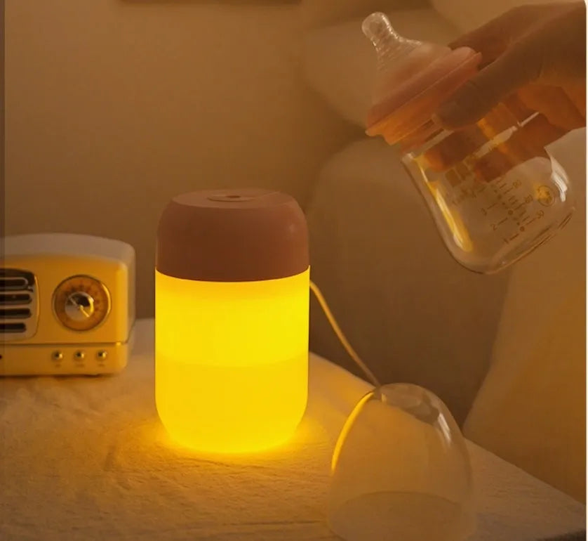 White cylindrical mini humidifier with USB cable on a wooden surface.
