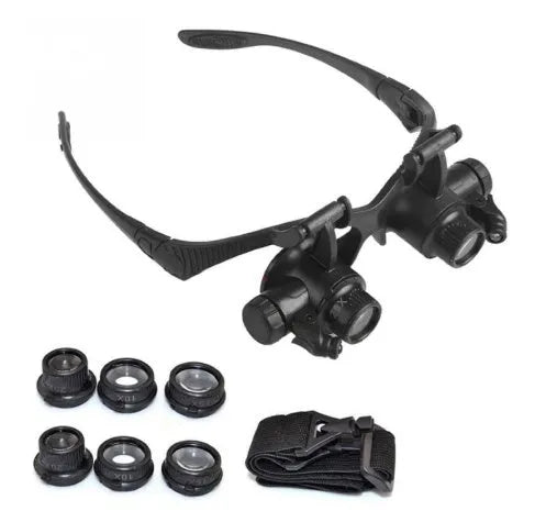 Black double eye magnifier glasses with LED lights and four sets of interchangeable lenses on a headband.