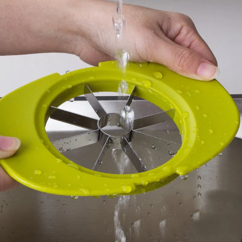 Green fruit slicer with three cutting sections for apple, tomato, and mango on a base